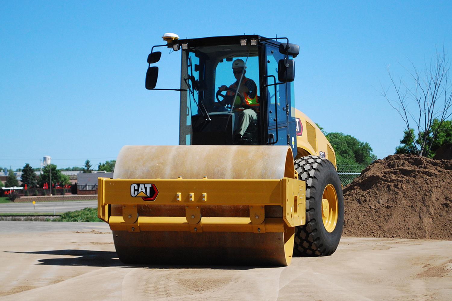 Compact rented CAT compaction equipment on a dirt road