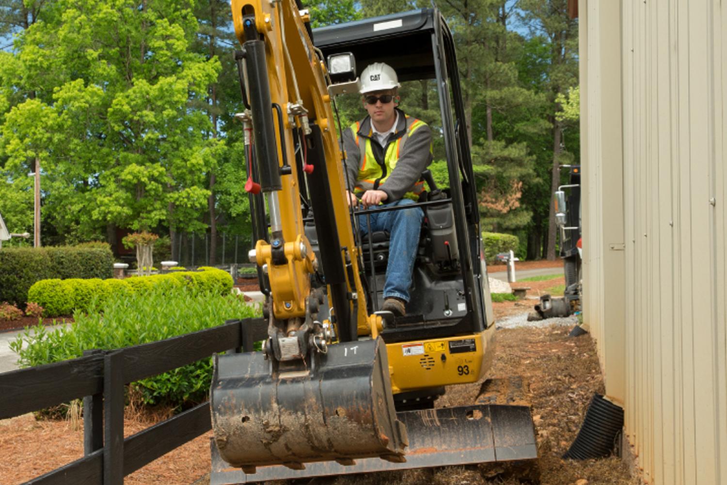 Small CAT excavator working on a suburban landscaping project